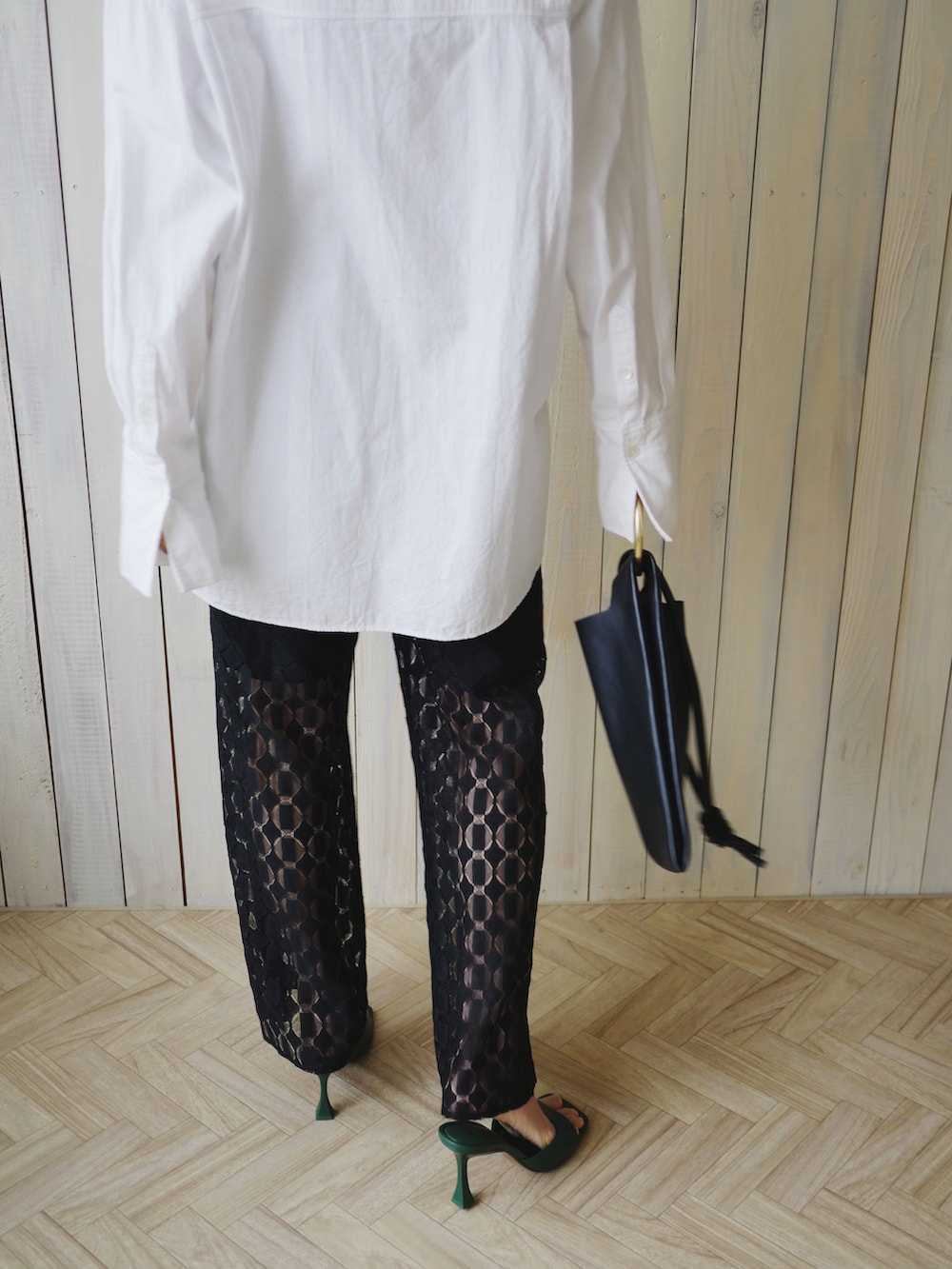 ブラック系のその他パンツ、ブラック系のショルダーバッグ、ホワイト系のシャツ/ブラウスを着用したレディースの春コーディネートの4枚目の写真