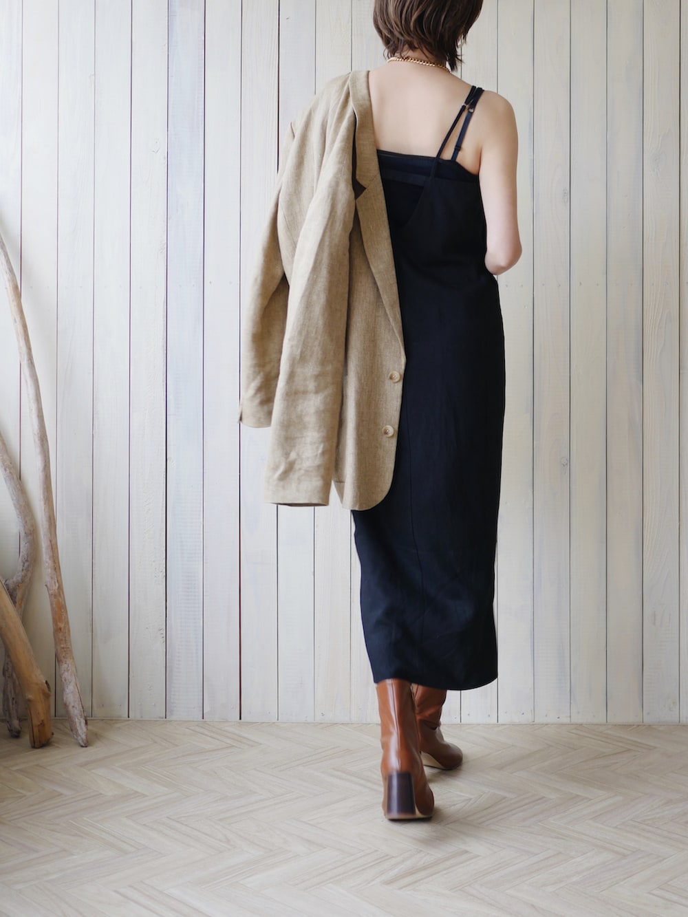 ベージュ系のテーラードジャケット、ブラック系のワンピース、ブラウン系のブーツを着用したレディースの春コーディネートの5枚目の写真