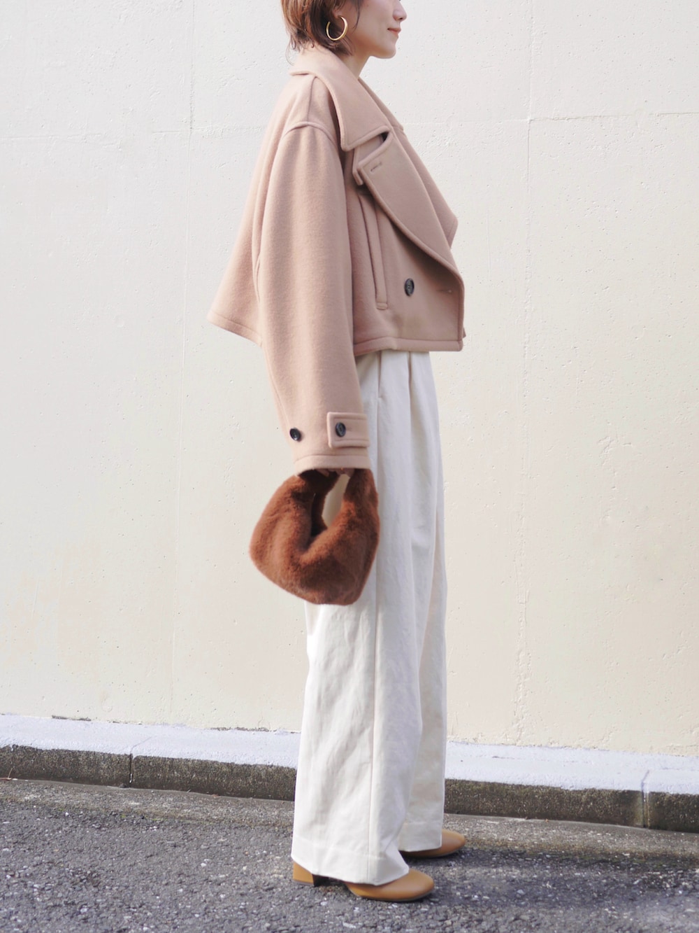 ベージュ系のピーコート、ベージュ系のニット/セーター、ホワイト系のその他パンツを着用したレディースの冬コーディネートの5枚目の写真