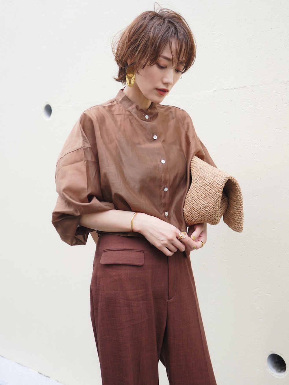 ブラウン系のシャツ/ブラウス、レッド系のスラックス、ブラウン系のかごバッグを着用したレディースの夏コーディネートの3枚目の写真