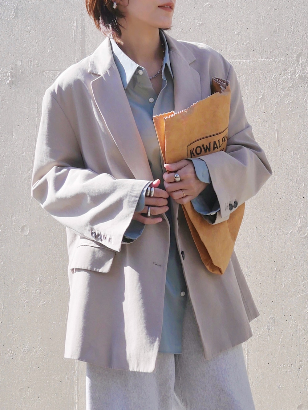 グレー系のスウェットパンツ、イエロー系のブーツ、ブラウン系のトートバッグを着用したレディースの春コーディネートの4枚目の写真