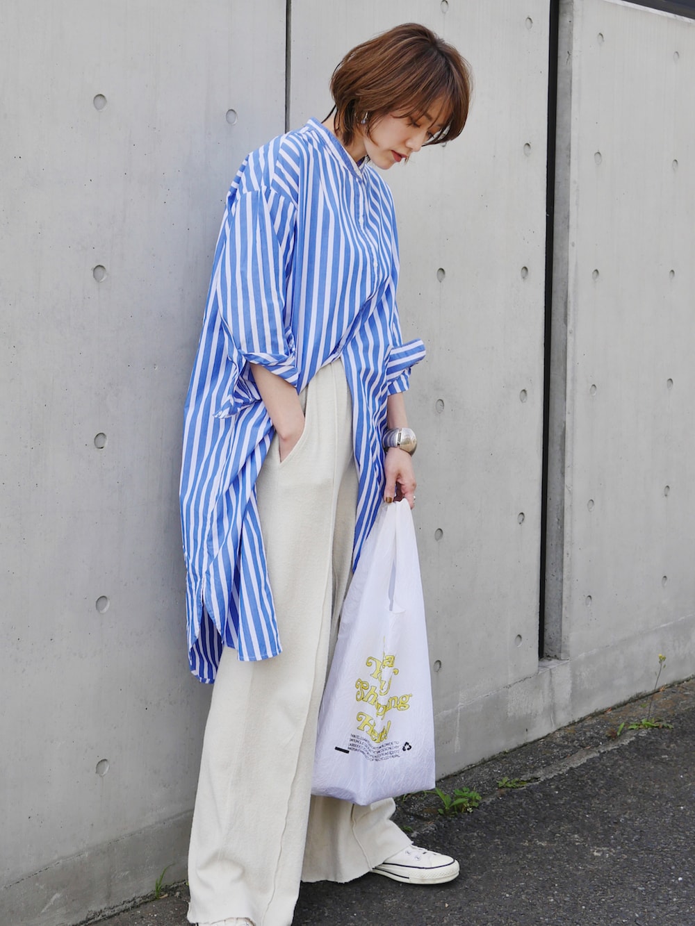 ブルー系のシャツワンピース、ベージュ系のその他パンツ、ホワイト系のスニーカーを着用したレディースの春コーディネートの2枚目の写真