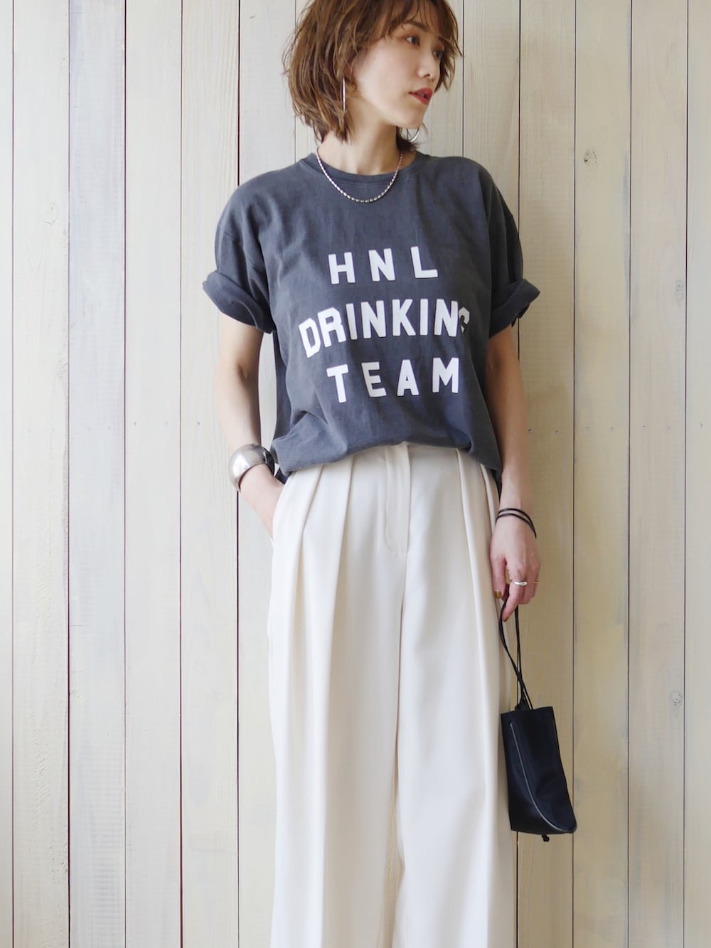 ブラック系のTシャツ/カットソー、ホワイト系のその他パンツ、ブラック系のショルダーバッグを着用したレディースの夏コーディネートの2枚目の写真