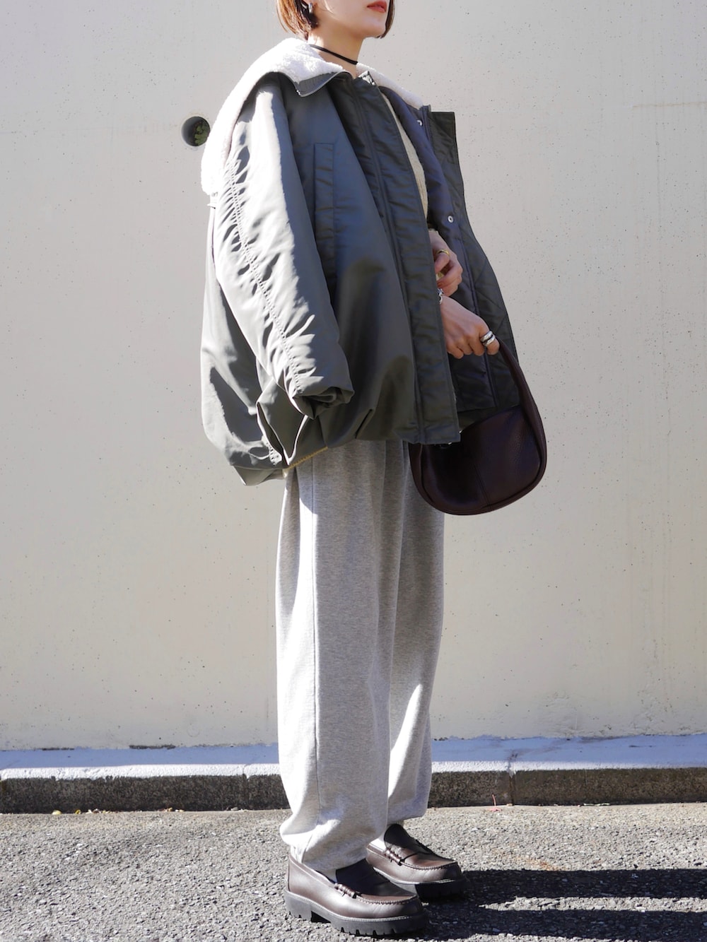 イエロー系のカーディガン/ボレロ、グリーン系のブルゾン、グレー系のスウェットパンツを着用したレディースの冬コーディネートの4枚目の写真