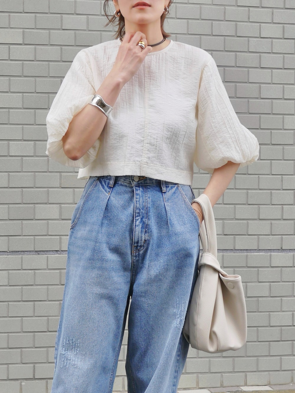 ホワイト系のシャツ/ブラウス、ブルー系のデニムパンツ、ブラウン系のスニーカーを着用したレディースの春コーディネートの4枚目の写真