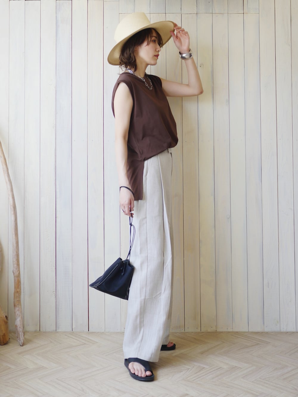 ベージュ系のその他パンツ、ブラウン系のTシャツ/カットソー、ブラック系のショルダーバッグを着用したレディースの夏コーディネートの3枚目の写真