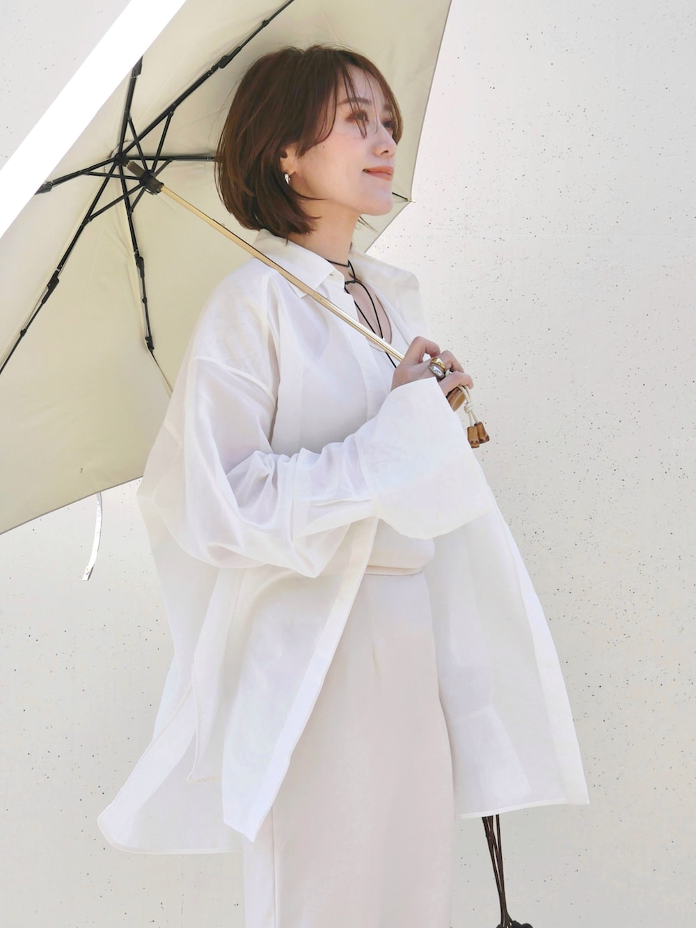 ホワイト系のシャツ/ブラウス、ホワイト系のスニーカー、ブラウン系のトートバッグを着用したレディースの春コーディネートの4枚目の写真