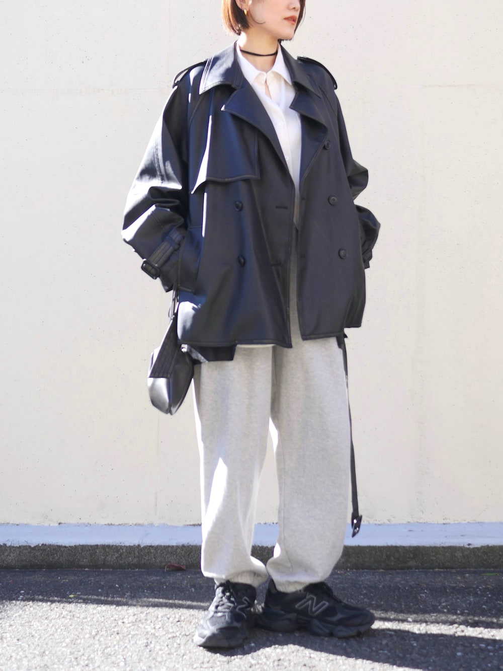 ブラック系のトレンチコート、グレー系のスウェットパンツ、ホワイト系のシャツ/ブラウスを着用したレディースの冬コーディネートの3枚目の写真