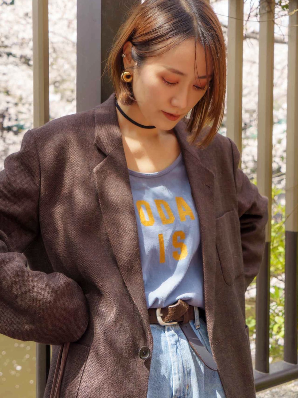 ブルー系のデニムパンツ、ブラウン系のテーラードジャケット、ベージュ系のエコバッグ/サブバッグを着用したレディースの秋コーディネートの2枚目の写真