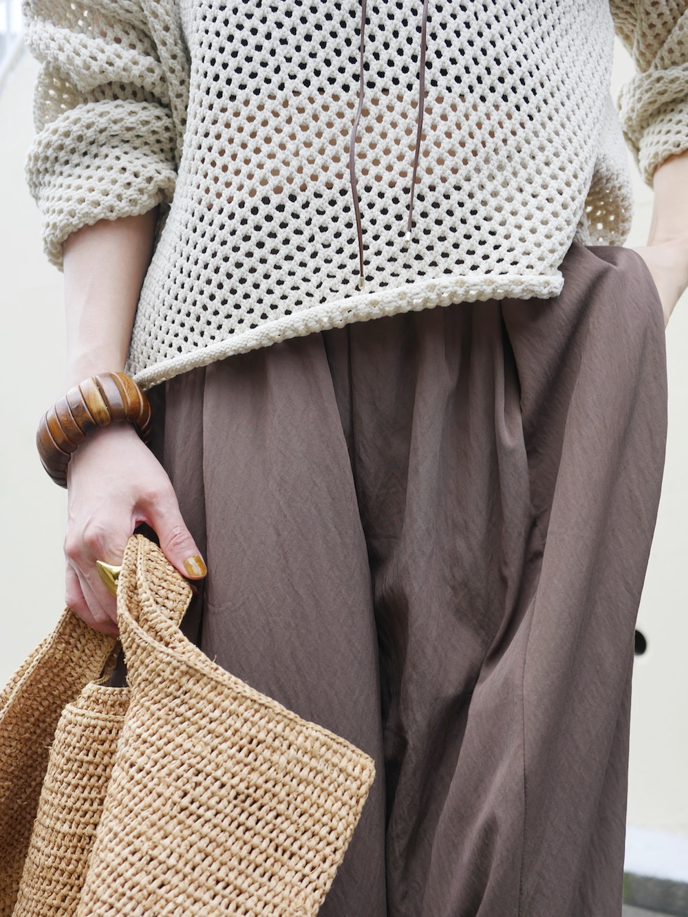 ホワイト系のニット/セーター、ブラウン系のその他パンツ、ブラウン系のかごバッグを着用したレディースの夏コーディネートの3枚目の写真