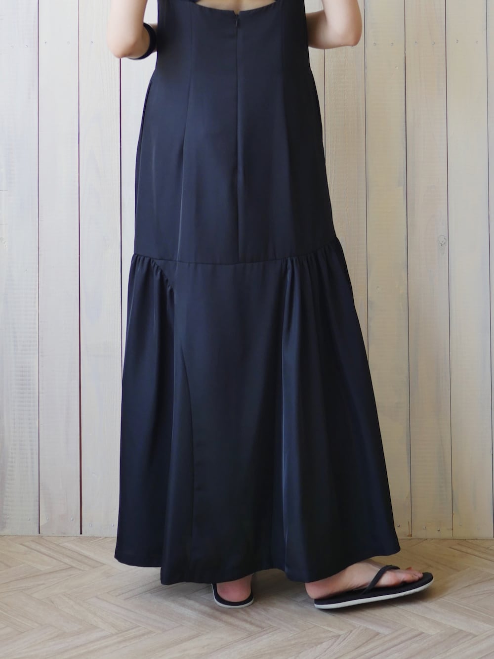 ブラック系のワンピース、ブラック系のサンダル、ゴールド系のピアス（両耳用）を着用したレディースの夏コーディネートの4枚目の写真