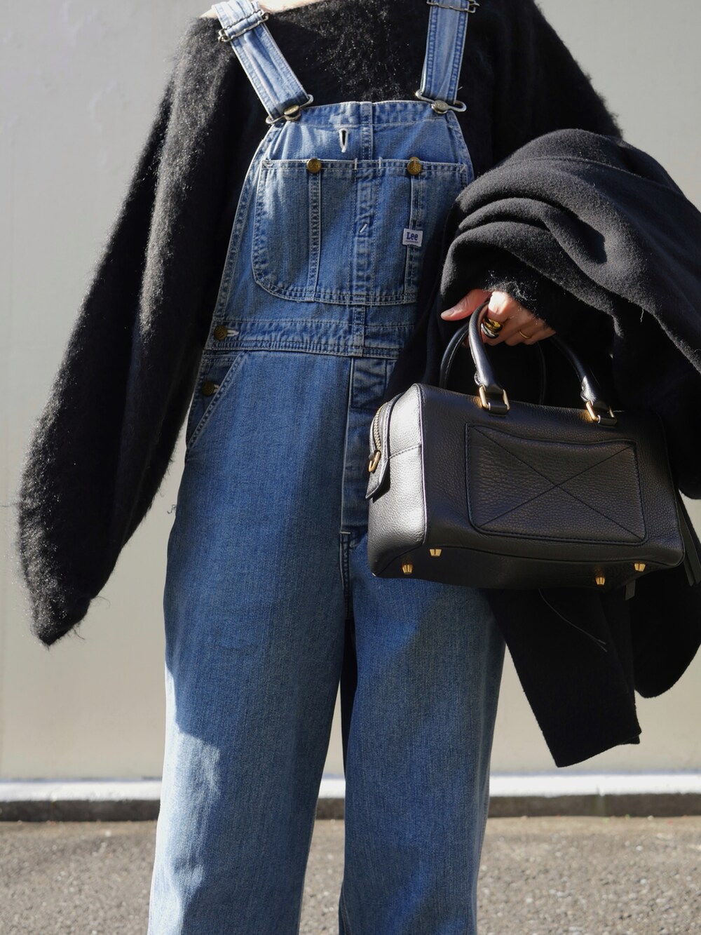 ブラック系のニット/セーター、ブラック系のブーツ、ブラック系のその他アウターを着用したレディースの冬コーディネートの4枚目の写真