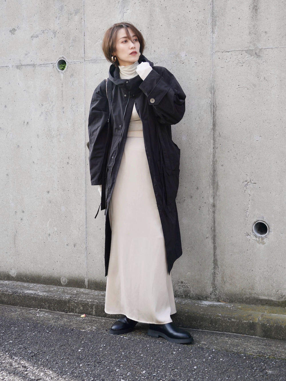 ブラック系のその他アウター、ホワイト系のスカート、ブラック系のブーツを着用したレディースの秋コーディネートの5枚目の写真