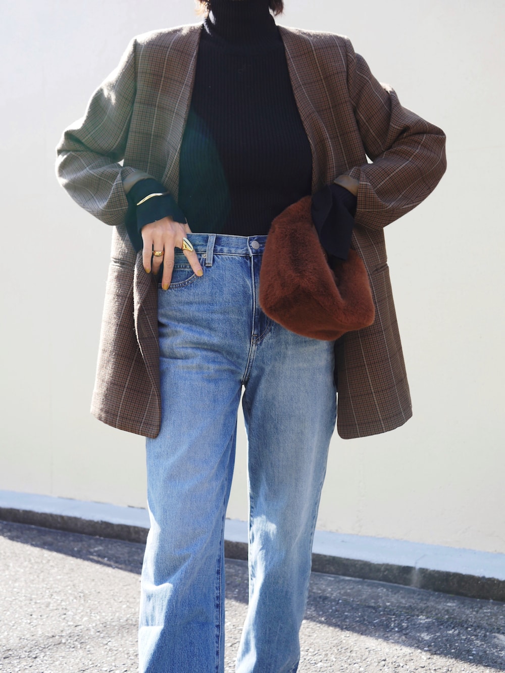 ブラック系のニット/セーター、ブラウン系のハンドバッグ、ブラウン系のノーカラージャケットを着用したレディースの冬コーディネートの3枚目の写真