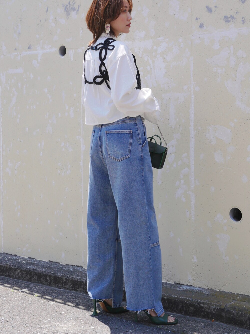ホワイト系のシャツ/ブラウス、ブルー系のデニムパンツ、グリーン系のショルダーバッグを着用したレディースの春コーディネートの3枚目の写真