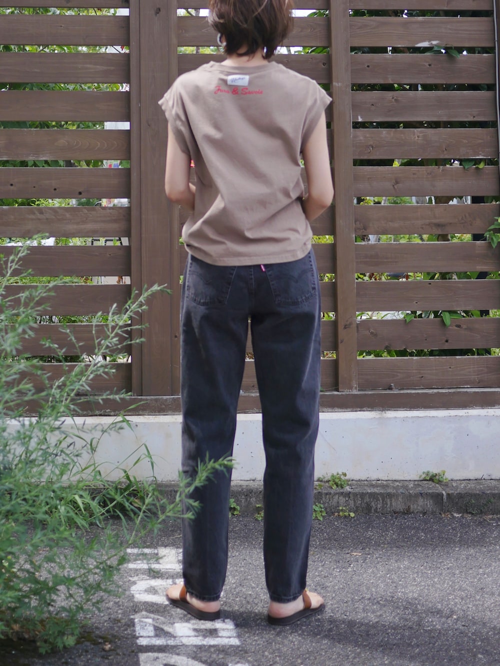 ベージュ系のTシャツ/カットソー、ブラウン系のショルダーバッグ、ブラック系のデニムパンツを着用したレディースの夏コーディネートの5枚目の写真