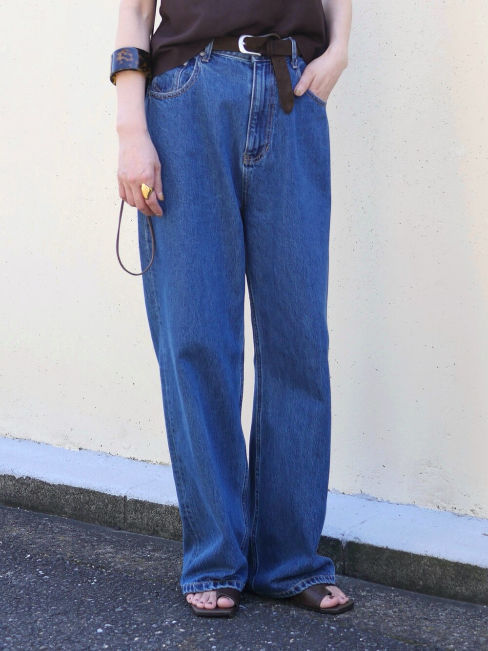 ブルー系のデニムパンツ、ブラウン系のサンダル、ベージュ系のエコバッグ/サブバッグを着用したレディースの夏コーディネートの4枚目の写真
