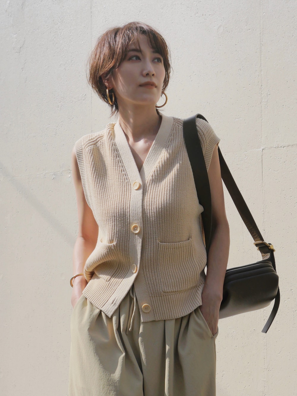 グリーン系のその他パンツ、グリーン系のショルダーバッグ、ホワイト系のカーディガン/ボレロを着用したレディースの秋コーディネートの2枚目の写真