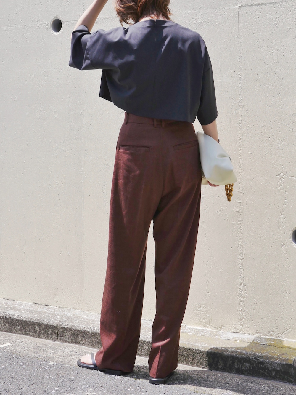 レッド系のスラックス、ホワイト系のショルダーバッグ、ブラック系のTシャツ/カットソーを着用したレディースの春コーディネートの4枚目の写真