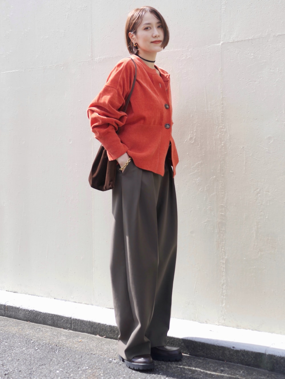 ブラウン系のローファー、グリーン系のその他パンツ、ベージュ系のエコバッグ/サブバッグを着用したレディースの秋コーディネートの2枚目の写真