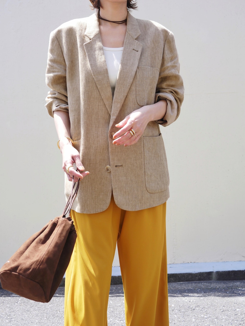 ベージュ系のテーラードジャケット、イエロー系のその他パンツ、ブラウン系のスニーカーを着用したレディースの春コーディネートの4枚目の写真