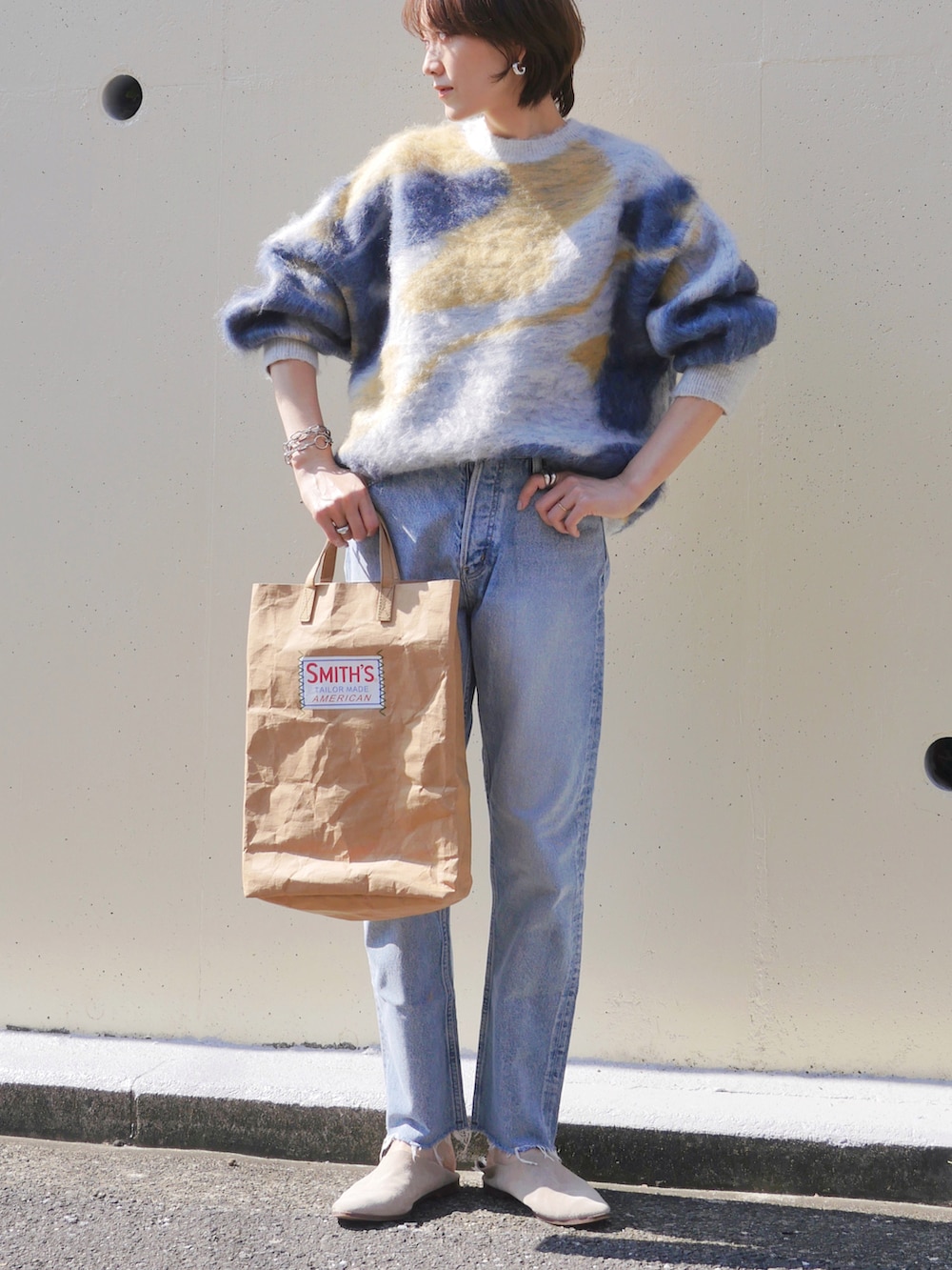 ブルー系のニット/セーター、ベージュ系のトートバッグ、シルバー系のピアス（両耳用）を着用したレディースの秋コーディネートの4枚目の写真