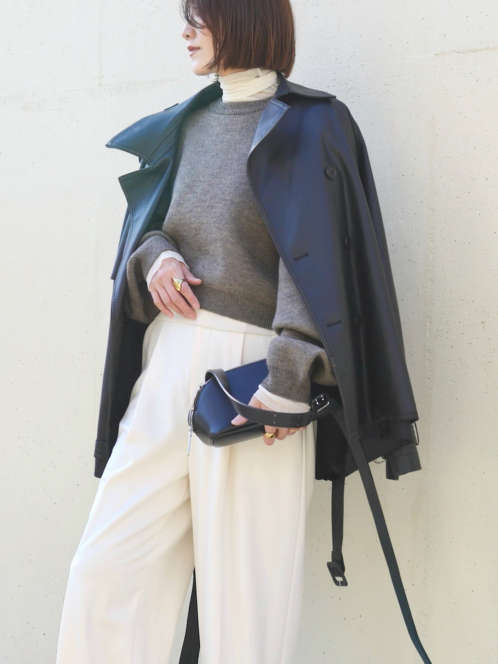 ブラウン系のニット/セーター、ブラック系のブーツ、ホワイト系のTシャツ/カットソーを着用したレディースの冬コーディネートの2枚目の写真