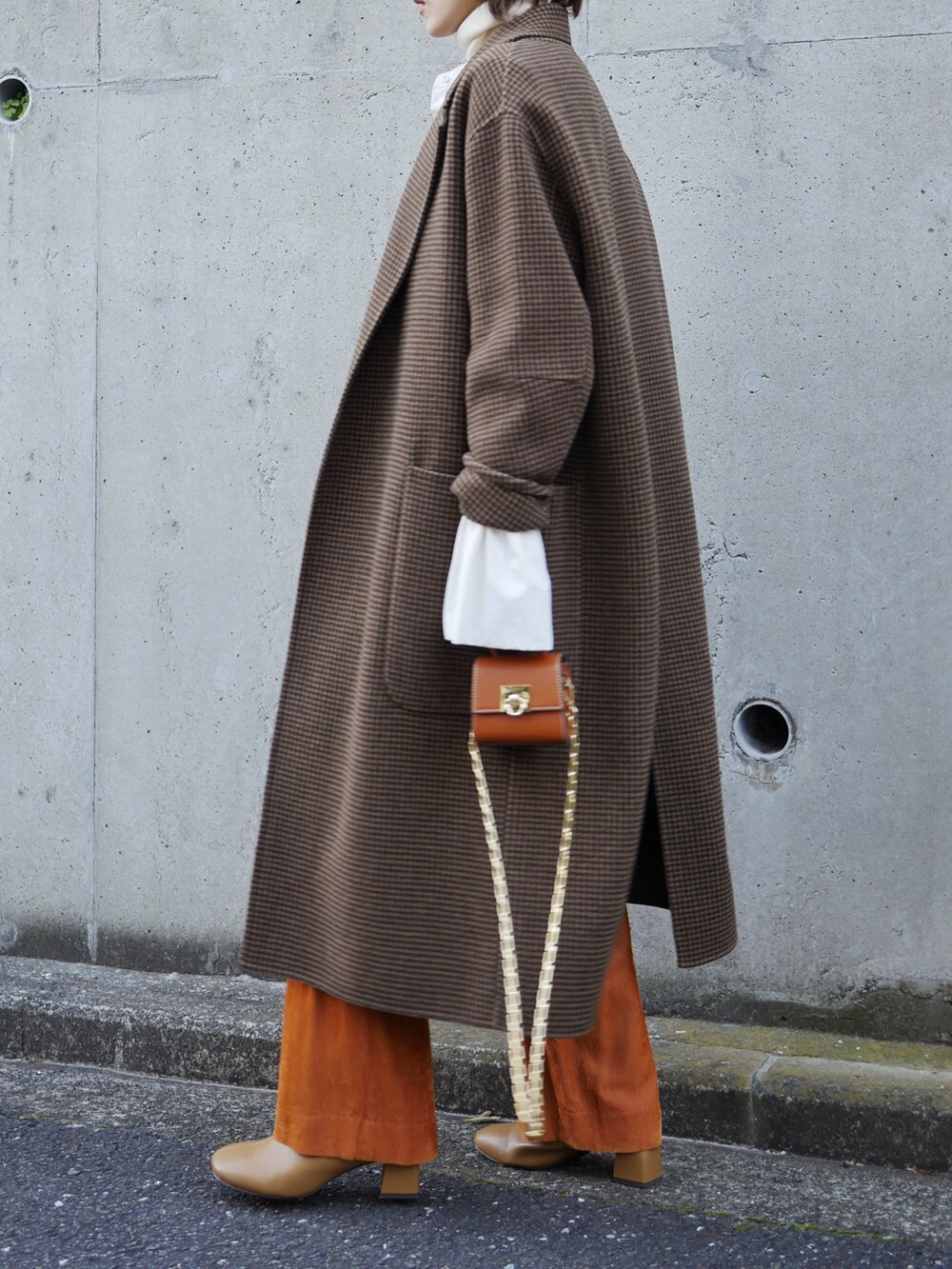 ホワイト系のシャツ/ブラウス、イエロー系のその他アウター、ブラウン系のチェスターコートを着用したレディースの冬コーディネートの2枚目の写真