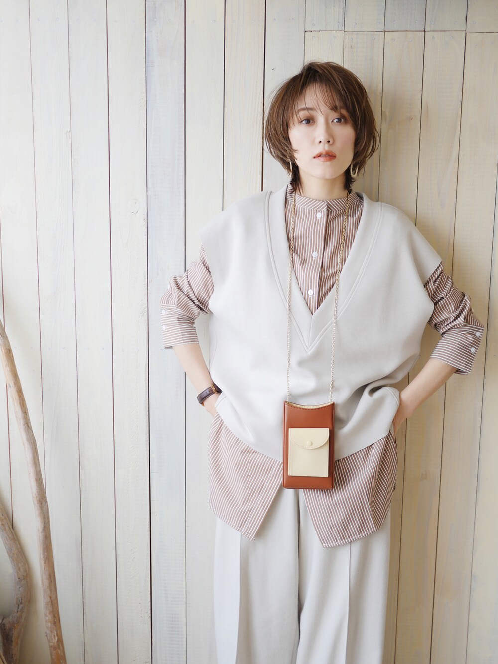 ブラウン系のシャツ/ブラウス、グレー系のベスト、ホワイト系のスラックスを着用したレディースの春コーディネートの4枚目の写真