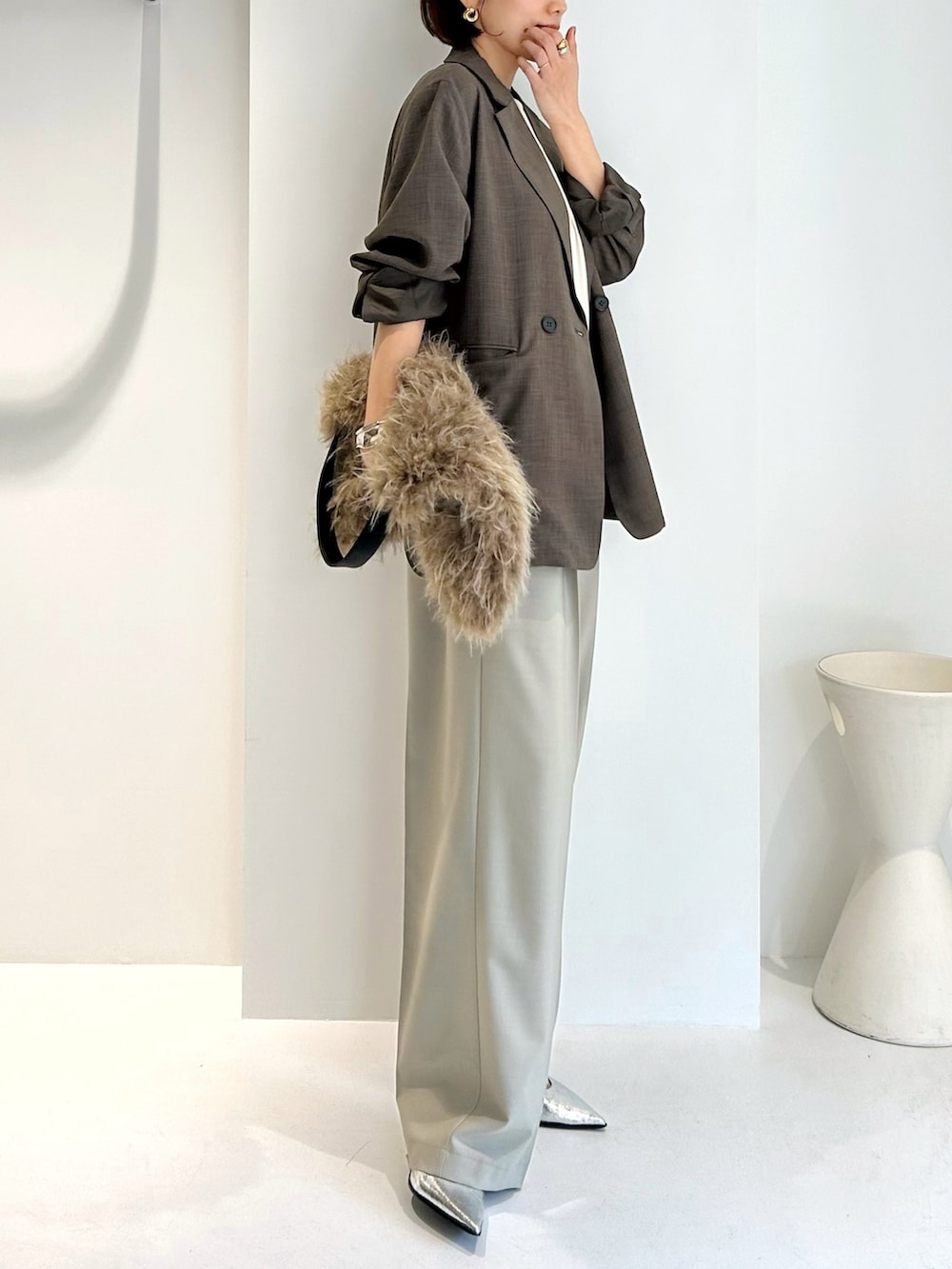 ベージュ系のテーラードジャケット、ベージュ系のショルダーバッグ、ベージュ系のスラックスを着用したレディースの秋コーディネートの2枚目の写真