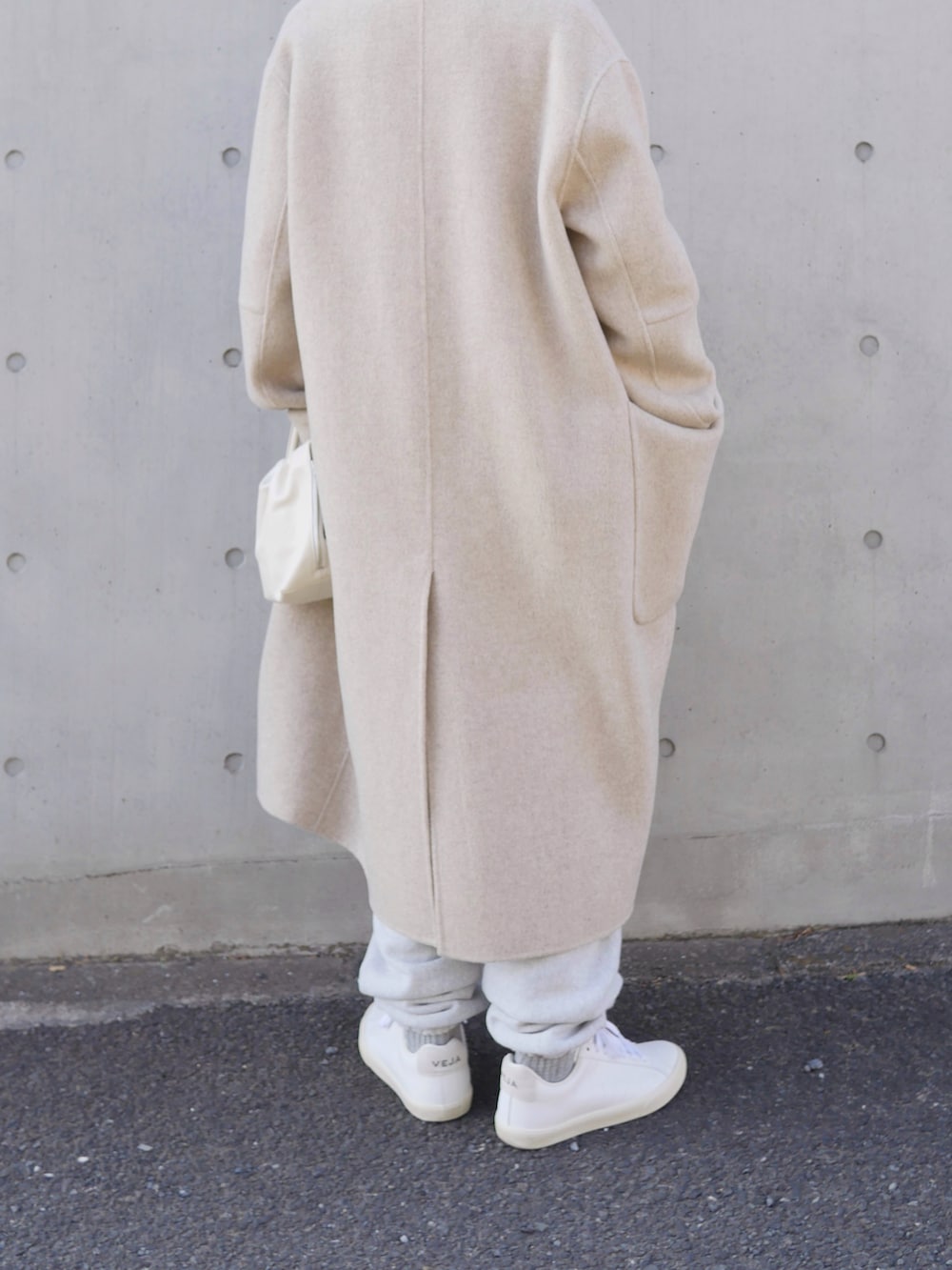 グレー系のスウェットパンツ、ホワイト系のスニーカー、ホワイト系のハンドバッグを着用したレディースの冬コーディネートの4枚目の写真