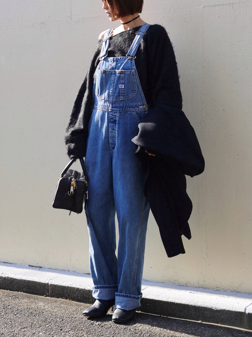 ブラック系のニット/セーター、ブラック系のブーツ、ブラック系のその他アウターを着用したレディースの冬コーディネートの2枚目の写真