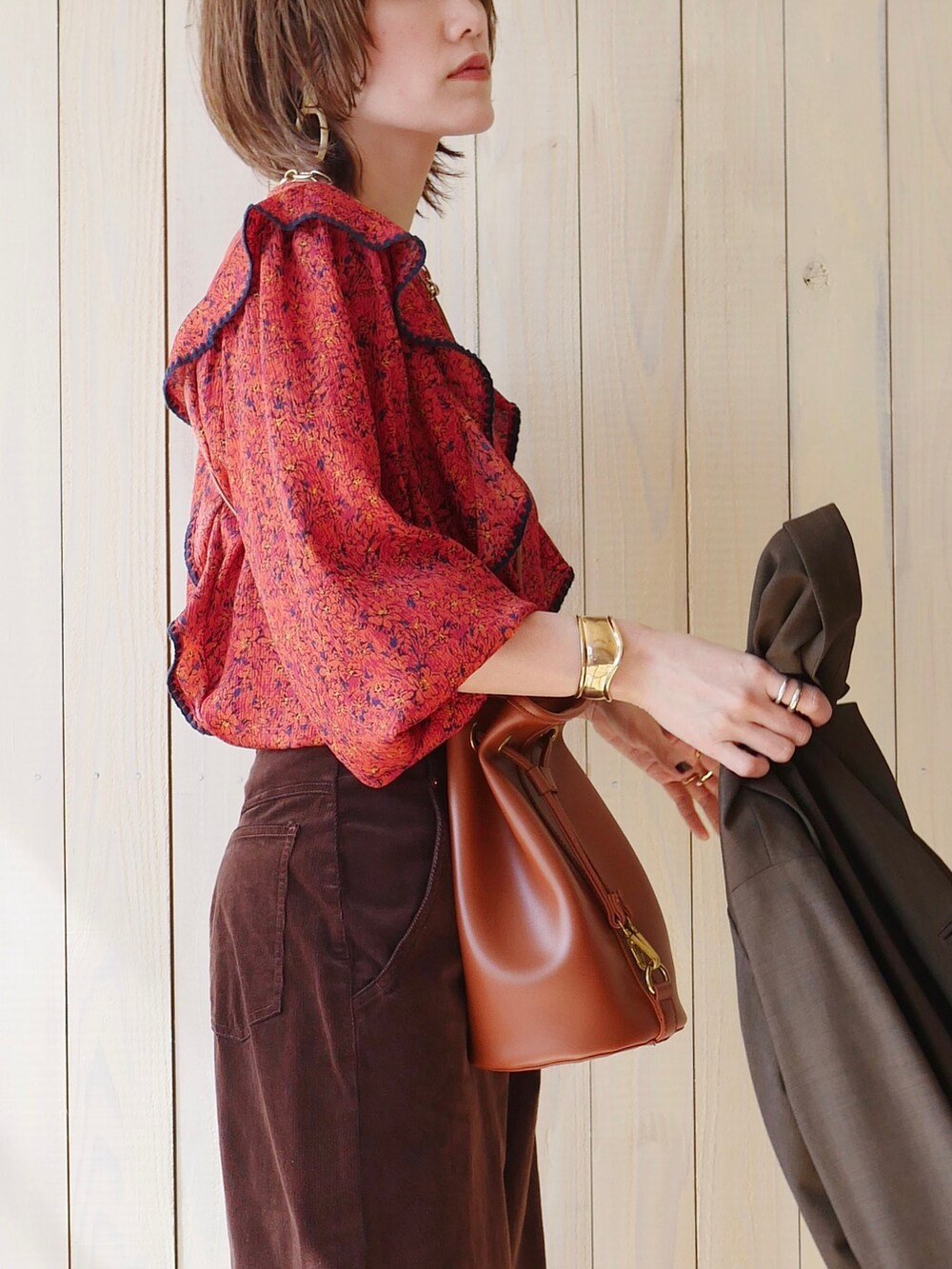 レッド系のシャツ/ブラウス、グリーン系のテーラードジャケット、ブラウン系のブーツを着用したレディースの春コーディネートの5枚目の写真