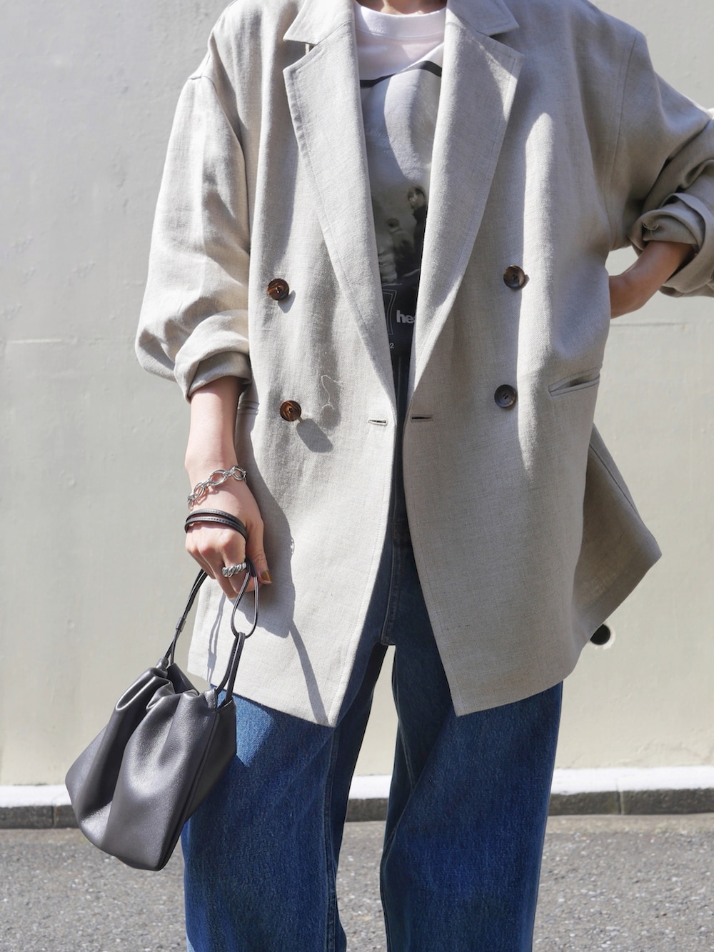 ホワイト系のTシャツ/カットソー、ブルー系のデニムパンツ、ブラウン系のショルダーバッグを着用したレディースの春コーディネートの2枚目の写真