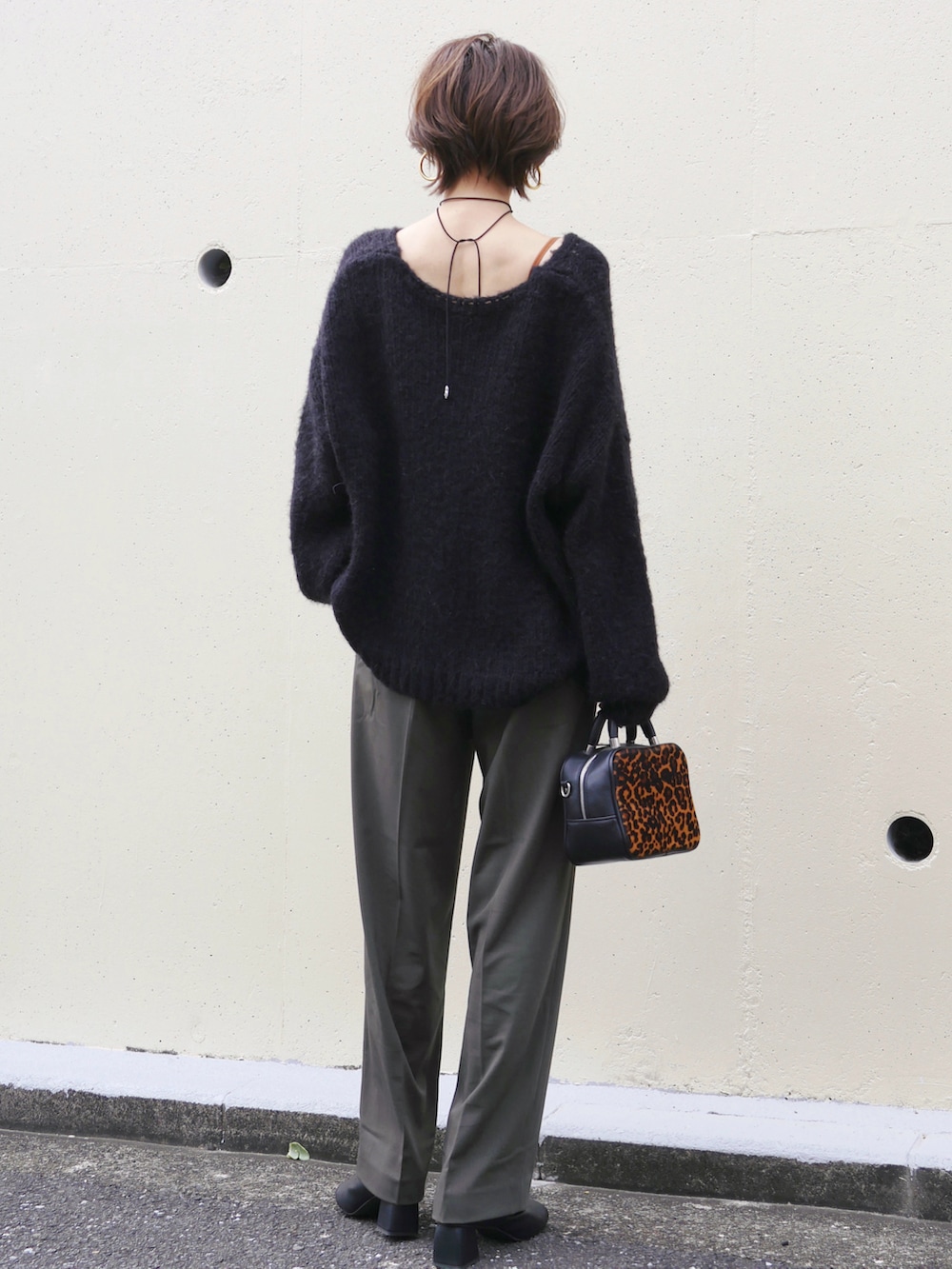 ブラック系のニット/セーター、ブラック系のブーツ、グリーン系のパンツを着用したレディースの秋コーディネートの3枚目の写真
