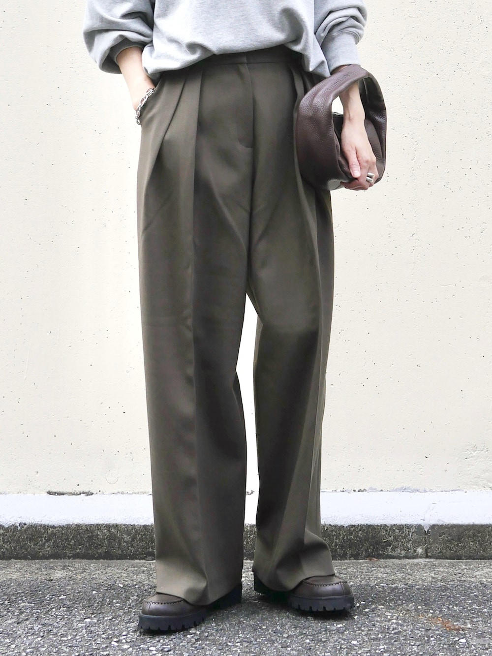 グリーン系のその他パンツ、レッド系のハンドバッグ、ブラウン系のローファーを着用したレディースの秋コーディネートの4枚目の写真