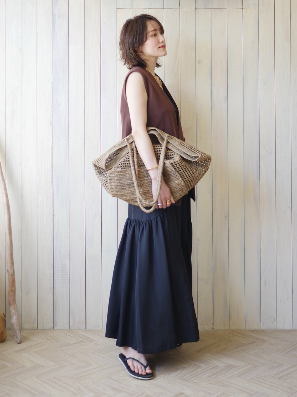 ブラック系のワンピース、ブラウン系のその他アウター、ベージュ系のかごバッグを着用したレディースの夏コーディネートの2枚目の写真