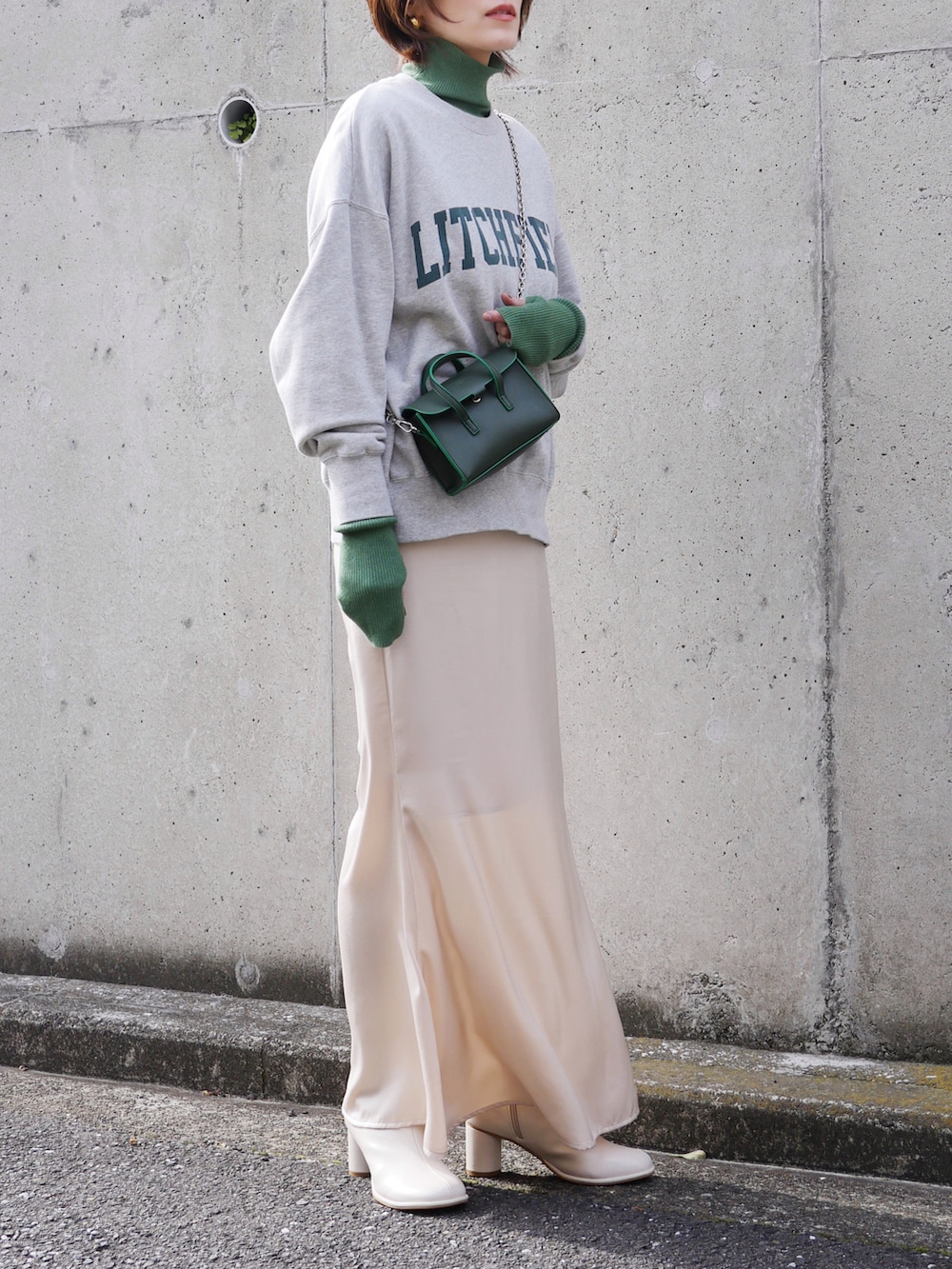 ホワイト系のスカート、グレー系のスウェット、グリーン系のニット/セーターを着用したレディースの冬コーディネートの2枚目の写真