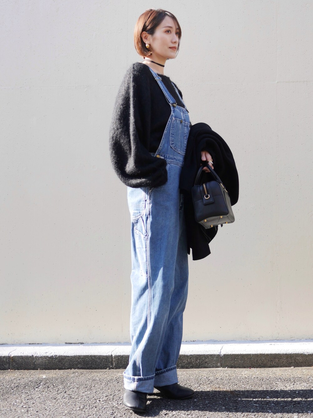 ブラック系のニット/セーター、ブラック系のブーツ、ブラック系のその他アウターを着用したレディースの冬コーディネートの3枚目の写真