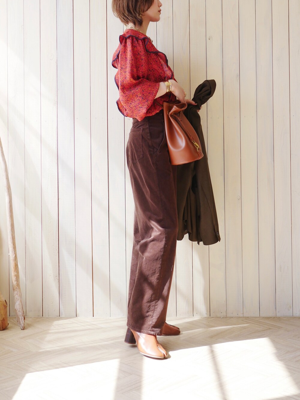 レッド系のシャツ/ブラウス、グリーン系のテーラードジャケット、ブラウン系のブーツを着用したレディースの春コーディネートの4枚目の写真