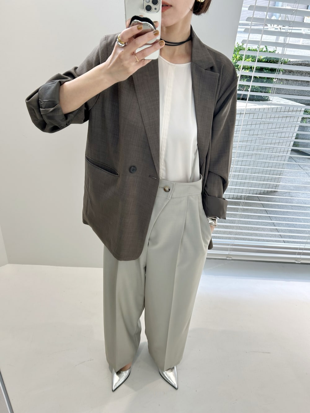 ベージュ系のテーラードジャケット、ベージュ系のショルダーバッグ、ベージュ系のスラックスを着用したレディースの秋コーディネートの4枚目の写真