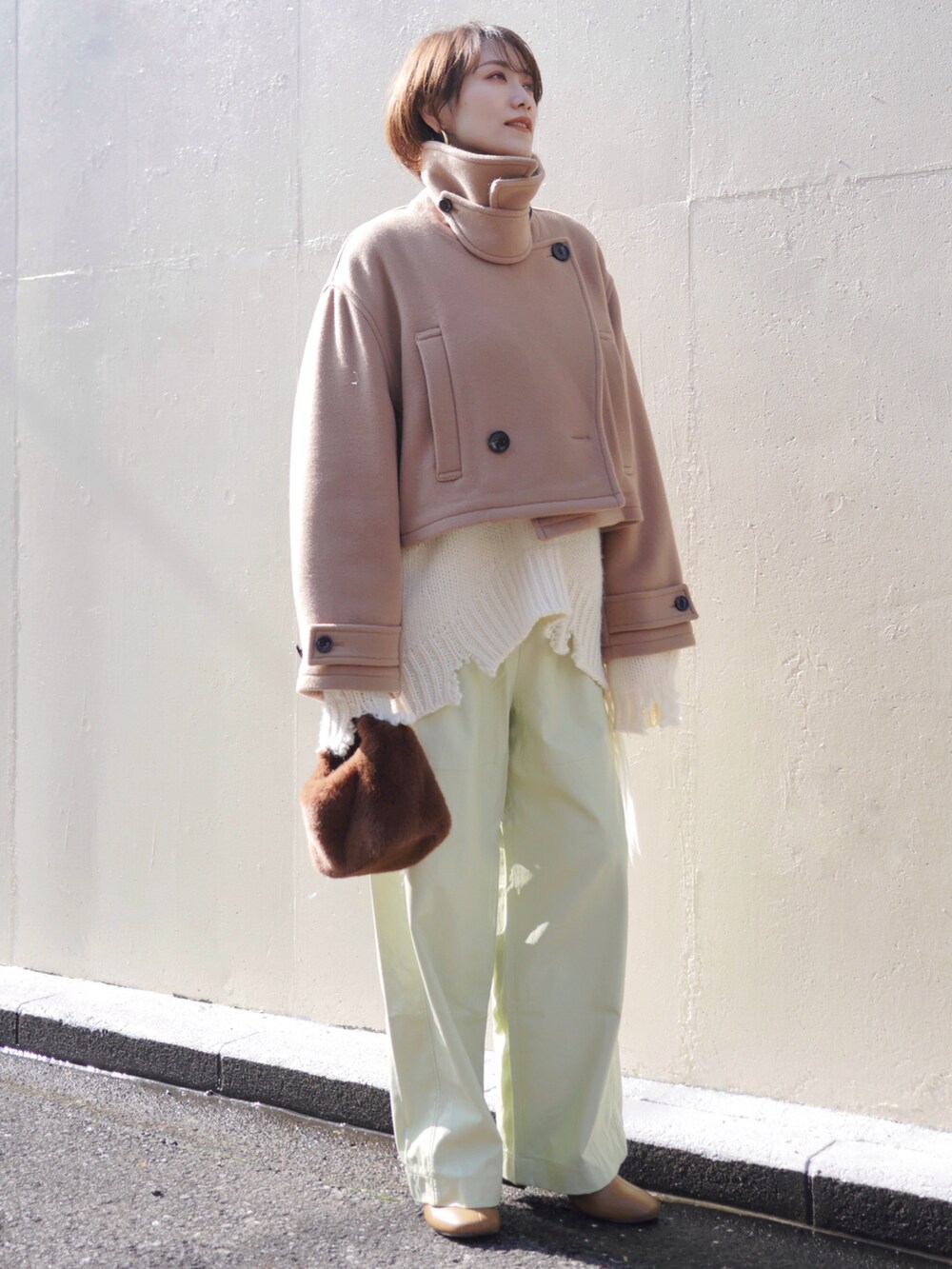 ベージュ系のピーコート、ホワイト系のニット/セーター、グリーン系のその他パンツを着用したレディースの冬コーディネートの3枚目の写真