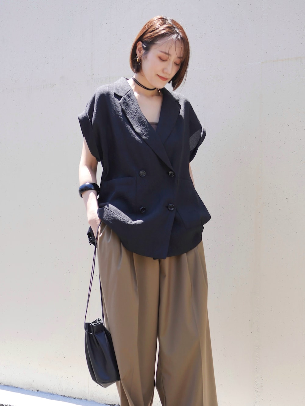 ブラック系のテーラードジャケット、ベージュ系のその他パンツ、ブラック系のサンダルを着用したレディースの夏コーディネートの2枚目の写真