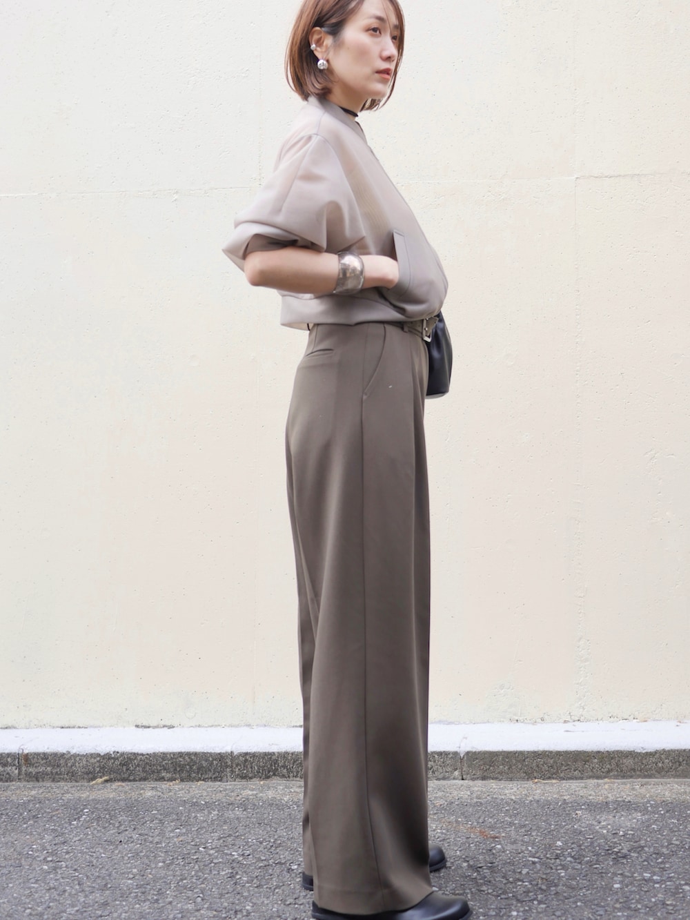 ベージュ系のブルゾン、グリーン系のその他パンツ、ブラック系のショルダーバッグを着用したレディースの春コーディネートの4枚目の写真