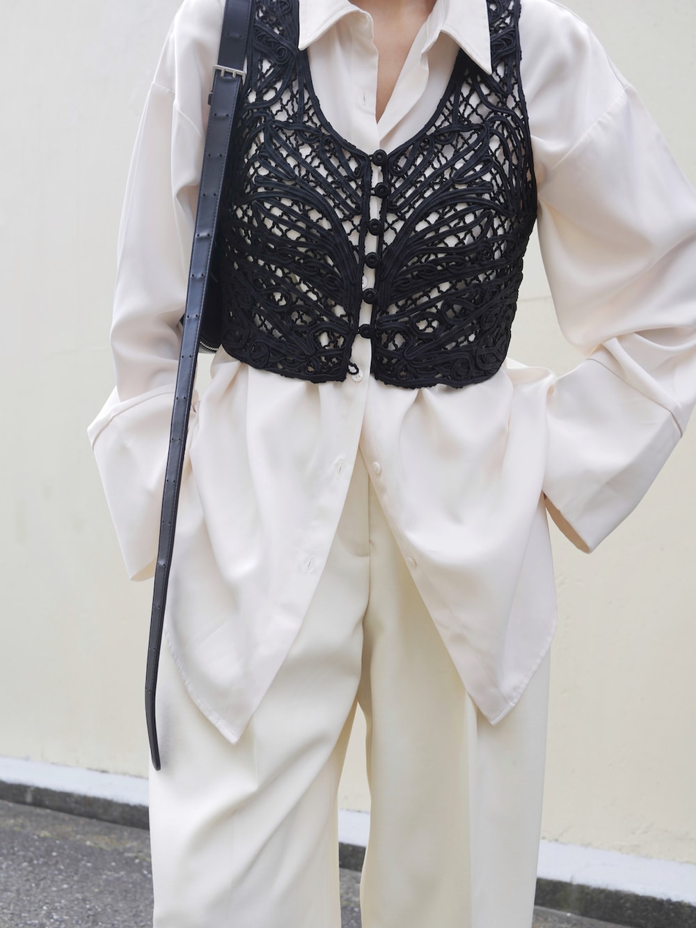 ホワイト系のシャツ/ブラウス、ブラック系のベスト、ホワイト系のスラックスを着用したレディースの春コーディネートの2枚目の写真