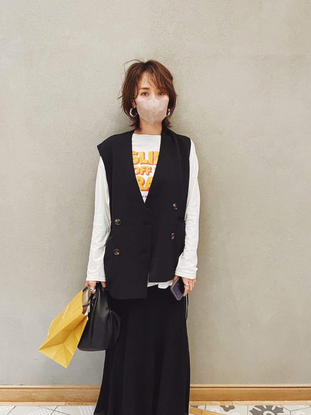 ホワイト系のTシャツ/カットソー、ブラック系のスカート、イエロー系のスニーカーを着用したレディースの春コーディネートの2枚目の写真