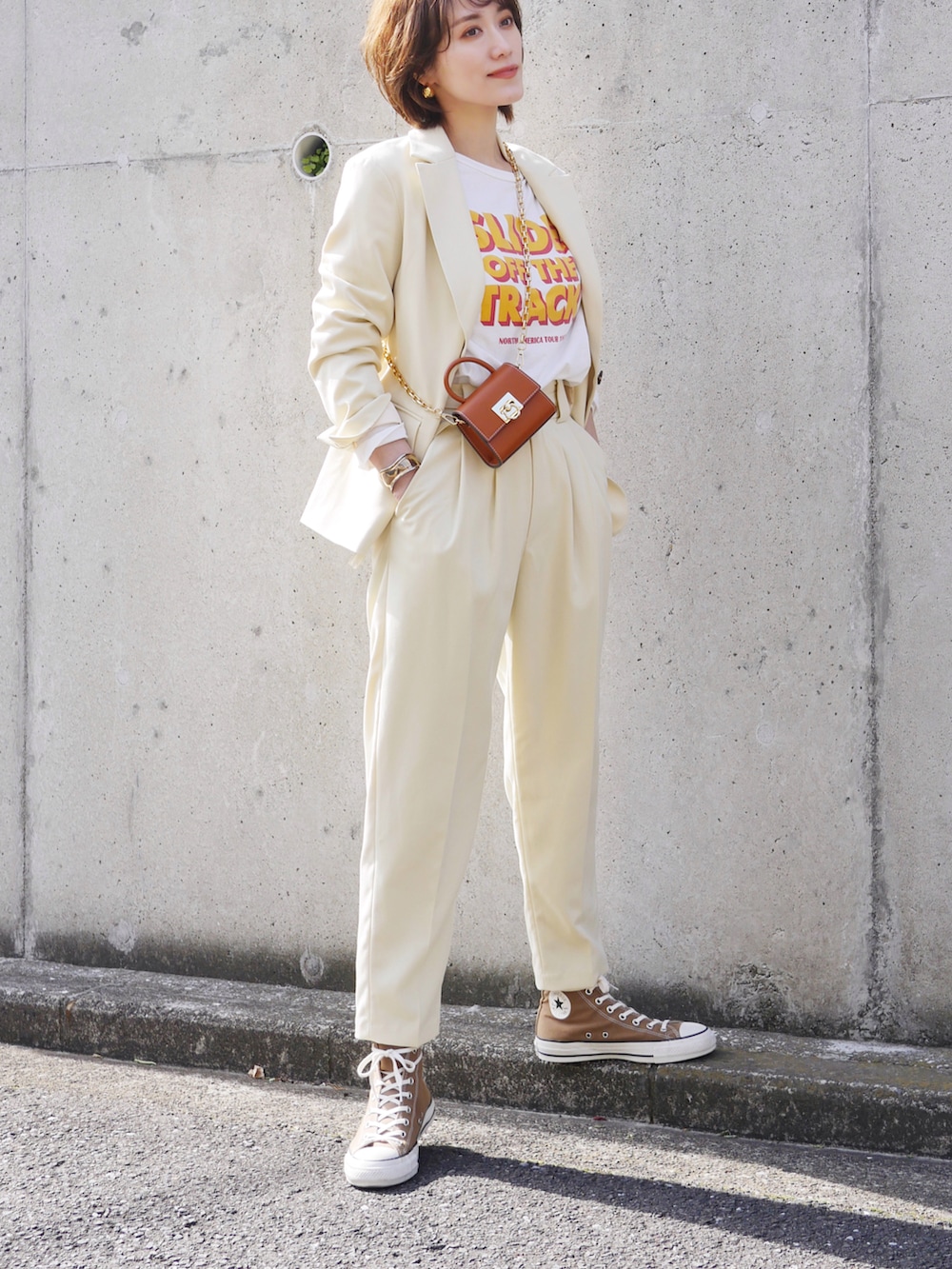 イエロー系のテーラードジャケット、イエロー系のその他パンツ、ホワイト系のTシャツ/カットソーを着用したレディースの冬コーディネートの3枚目の写真