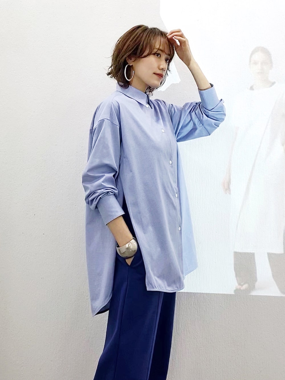 ブルー系のシャツ/ブラウス、ブルー系のパンツ、ブラック系のサンダルを着用したレディースの春コーディネートの3枚目の写真