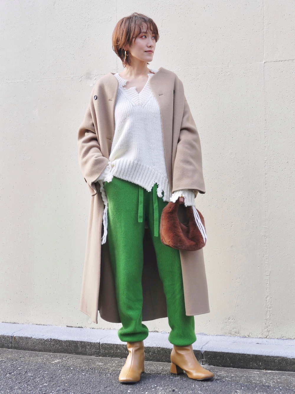 ホワイト系のニット/セーター、グリーン系のスラックス、ベージュ系のその他アウターを着用したレディースの冬コーディネートの3枚目の写真
