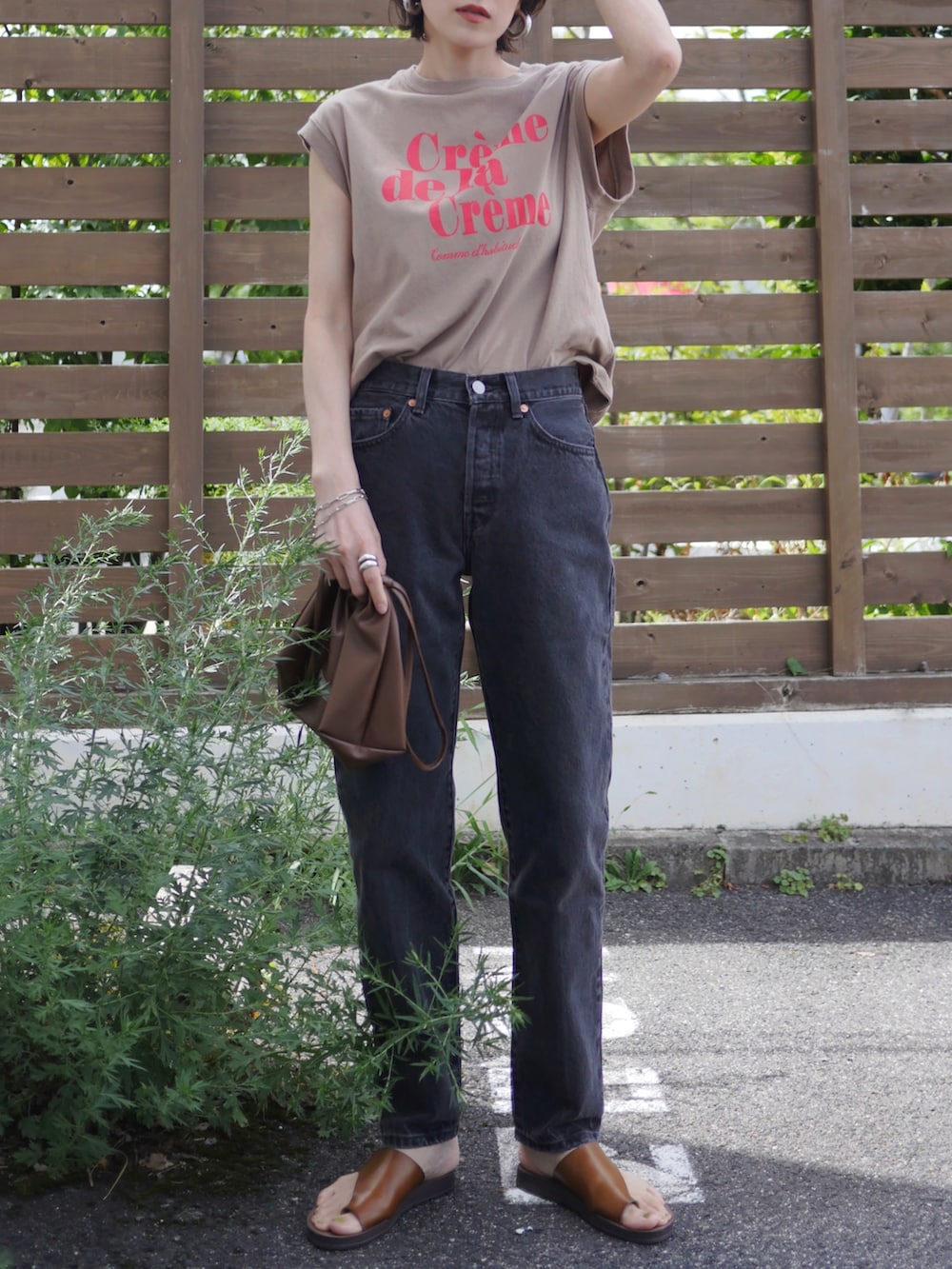 ベージュ系のTシャツ/カットソー、ブラウン系のショルダーバッグ、ブラック系のデニムパンツを着用したレディースの夏コーディネートの3枚目の写真